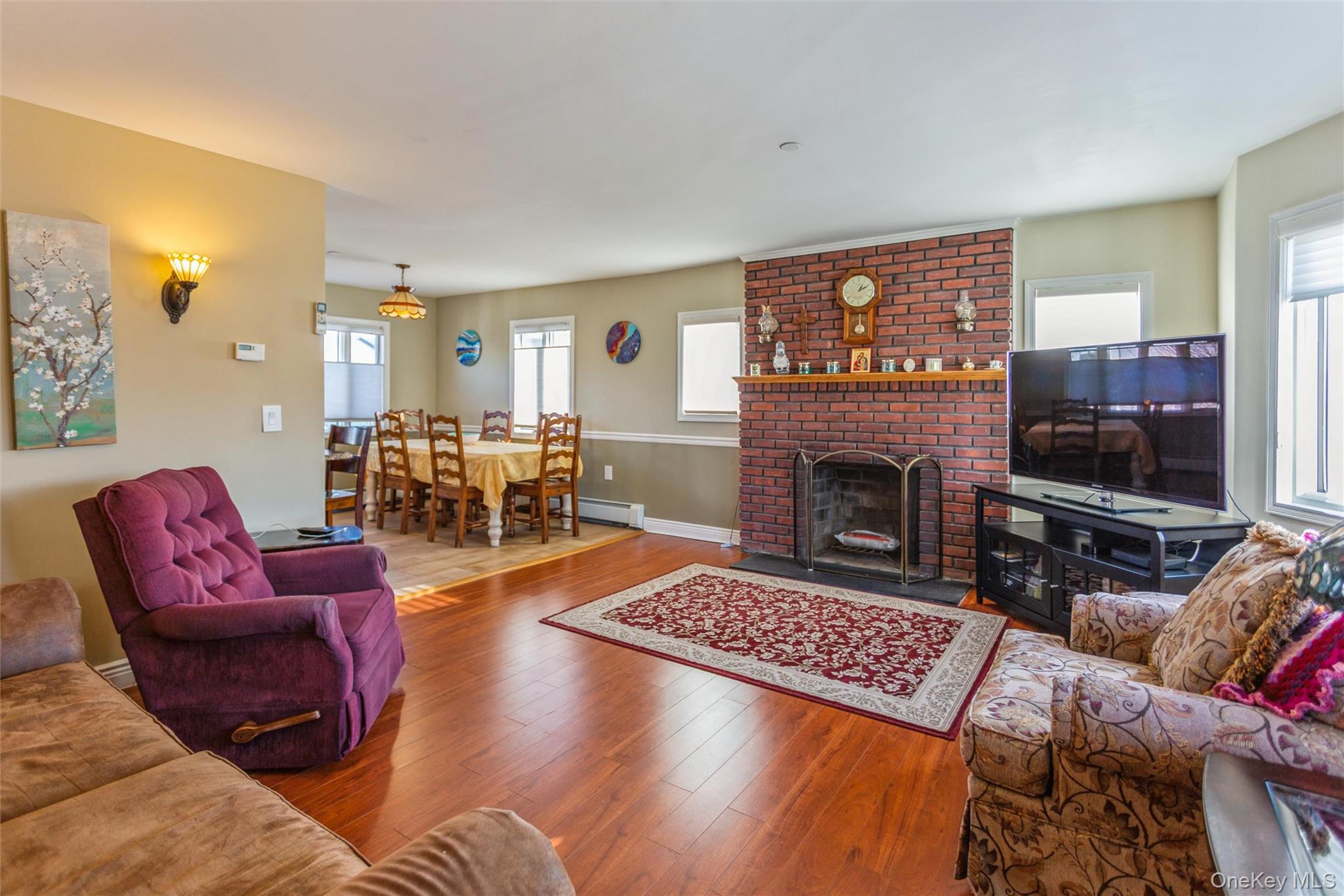 73 Parma Road Island Park, NY 11558 - Photo 3 of 37 a living room with furniture a flat screen tv and a fireplace
