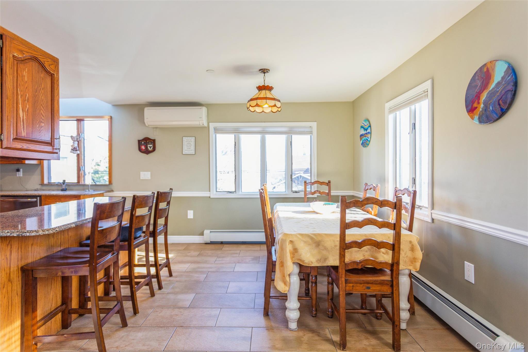 73 Parma Road Island Park, NY 11558 - Photo 6 of 37 a dining room with furniture a chandelier and wooden floor
