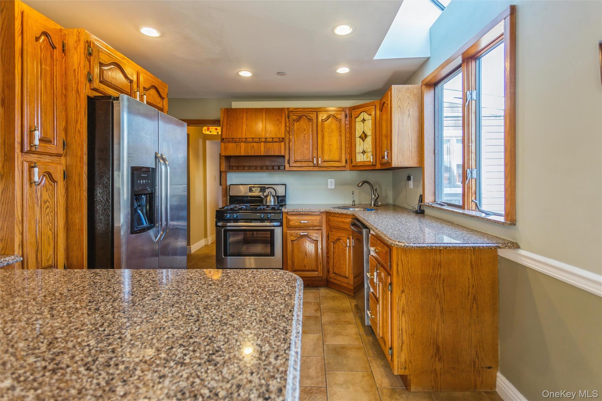 73 Parma Road Island Park, NY 11558 - Photo 8 of 37 a kitchen with stainless steel appliances granite countertop a refrigerator a stove top oven a sink and dishwasher