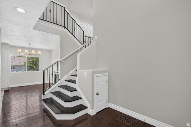 2223 North Pointe Meadow Loop Lehi, UT 84048 - Photo 8 of 56 Two-story staircase with dark wood-finish treads and risers, white stringers, and wrought iron balusters