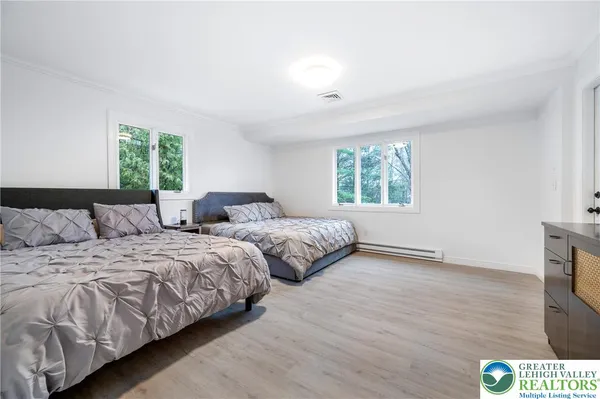 a bedroom with two beds and a wooden floor
