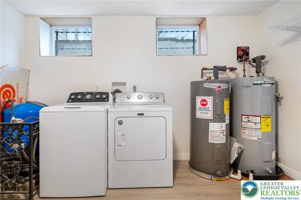 a utility room with fridge dryer and washer