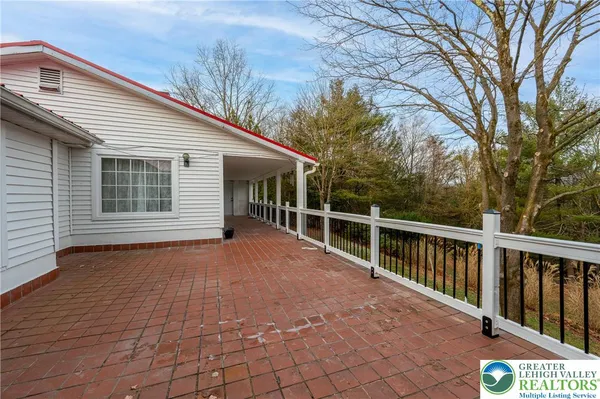 a view of backyard with large trees and wooden fence
