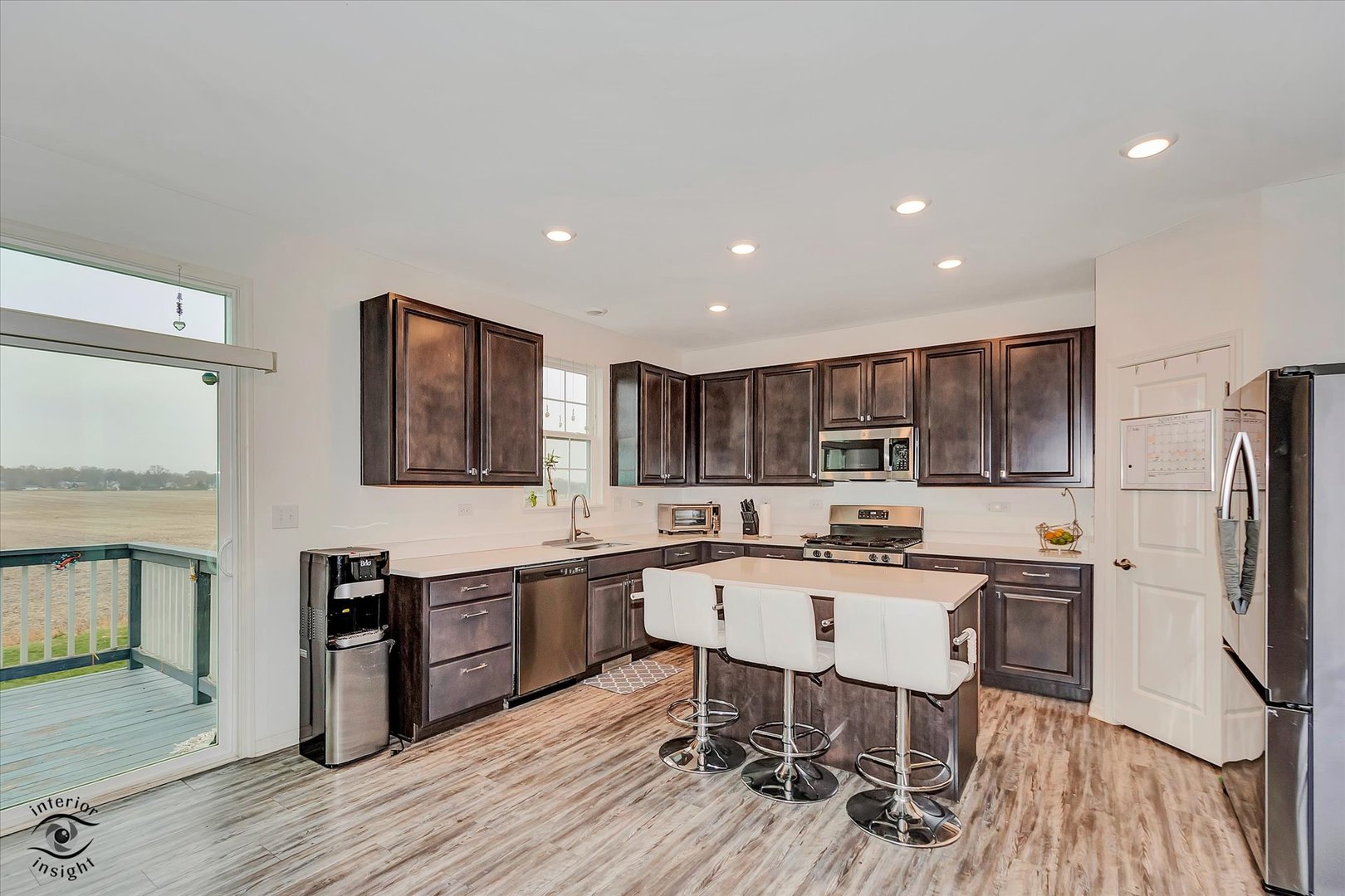 15101 Quincy Way Manhattan, IL 60442 - Photo 9 of 28 a kitchen with stainless steel appliances a dining table chairs microwave and sink