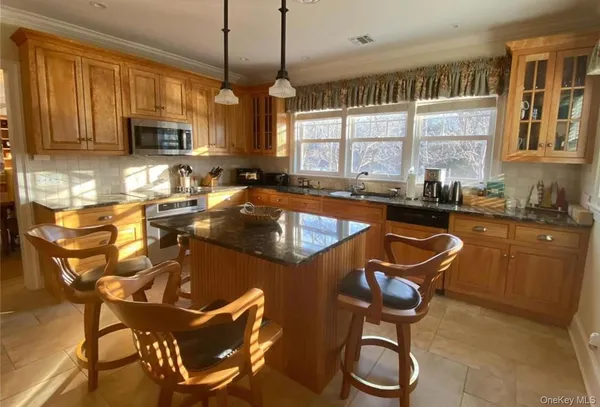a kitchen with granite countertop a sink a counter space appliances and cabinets