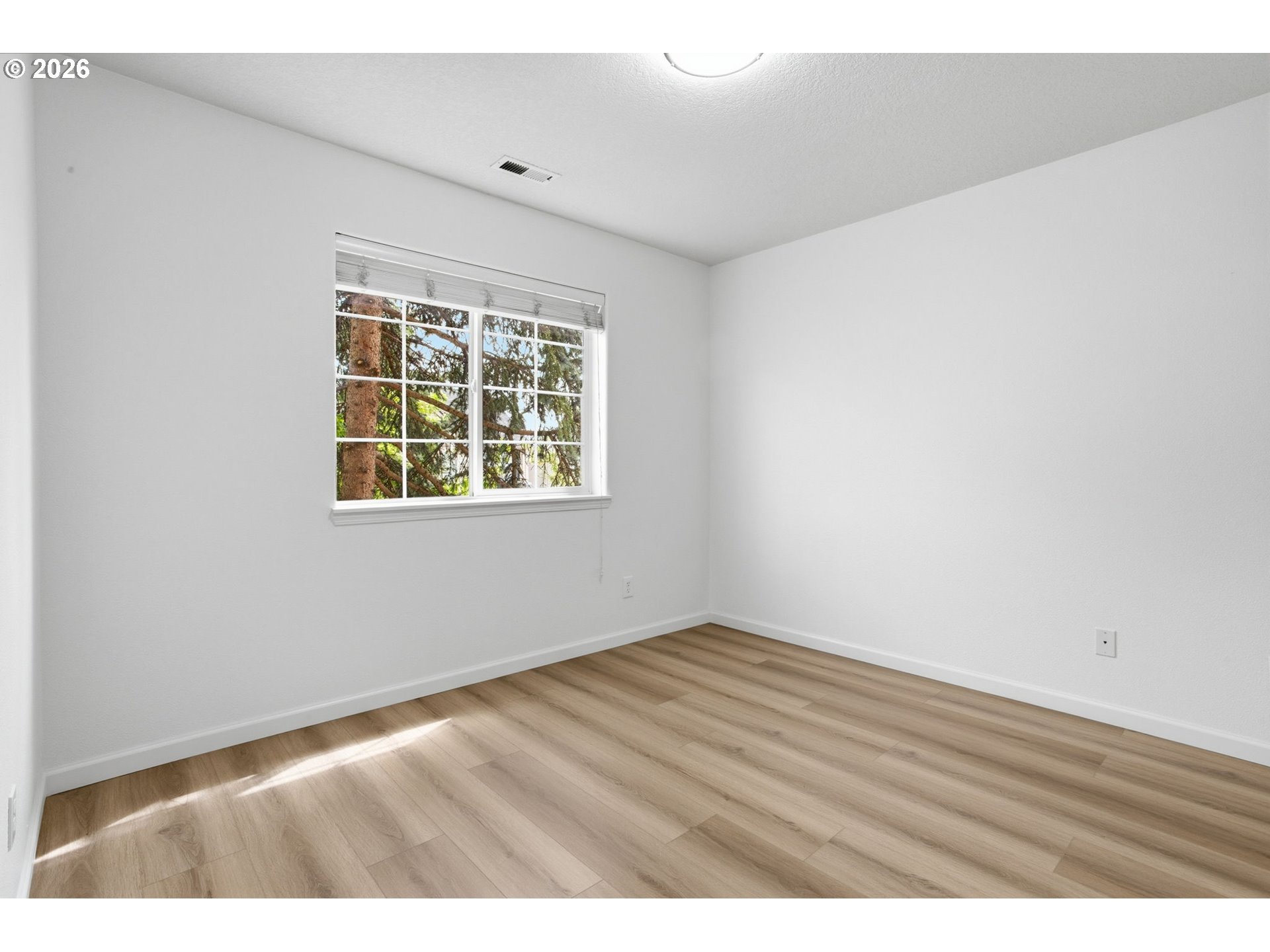 8911 Southwest Gravenstein Lane Tigard, OR 97224 - Photo 28 of 33 a view of an empty room with wooden floor and a window