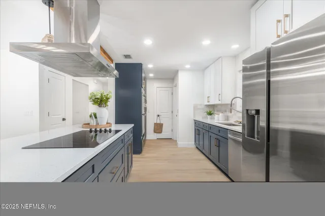a kitchen with kitchen island granite countertop a sink and a stove
