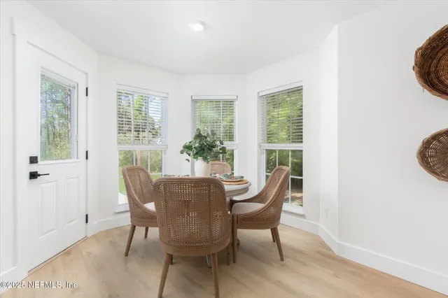 a dining room with furniture potted plants and wooden floor
