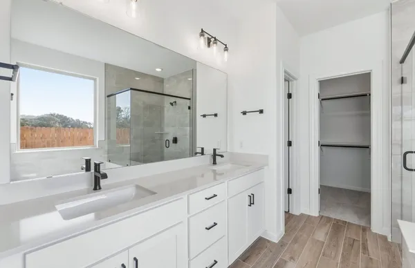 a spacious bathroom with a double vanity sink a mirror and a bathtub