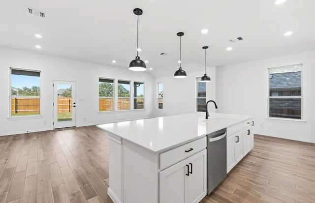 a view of center island wooden floor and windows