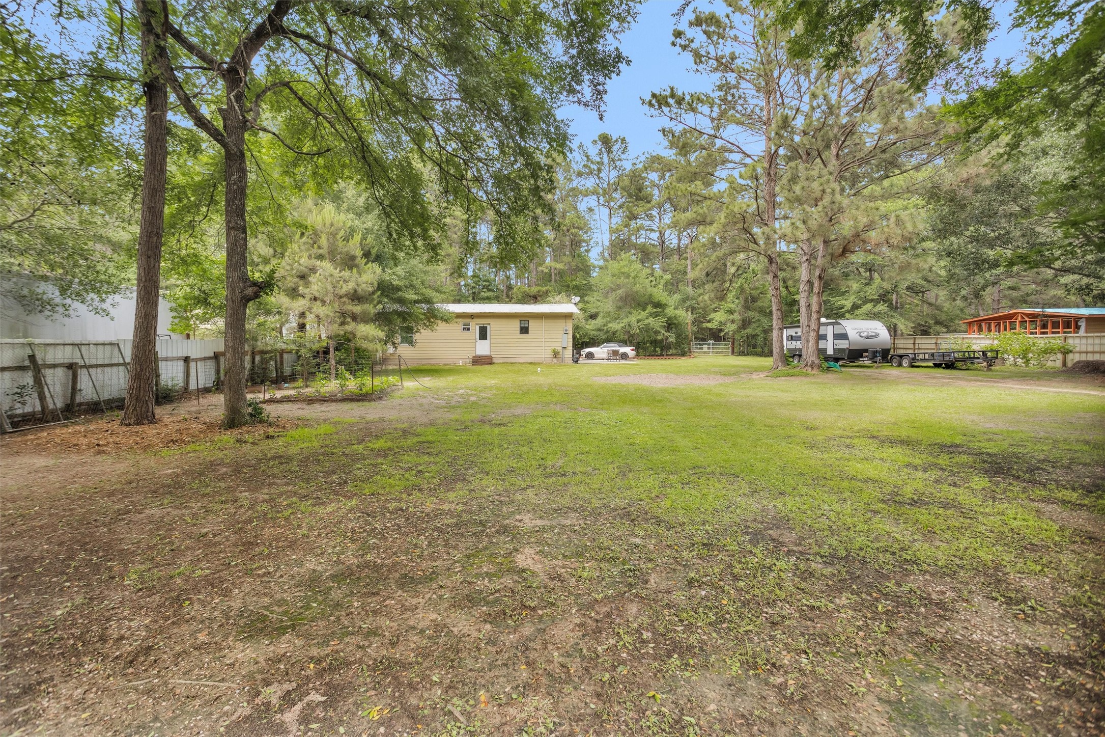 30806 Mellman Road Hempstead, TX 77445 - Photo 26 of 35 Oh look, there is a garden on the left! Your guests can stay in the home at the back of the property and there is room for an RV in the back also. The white gate allows whomever is staying at the guest house to enter without waking you up.