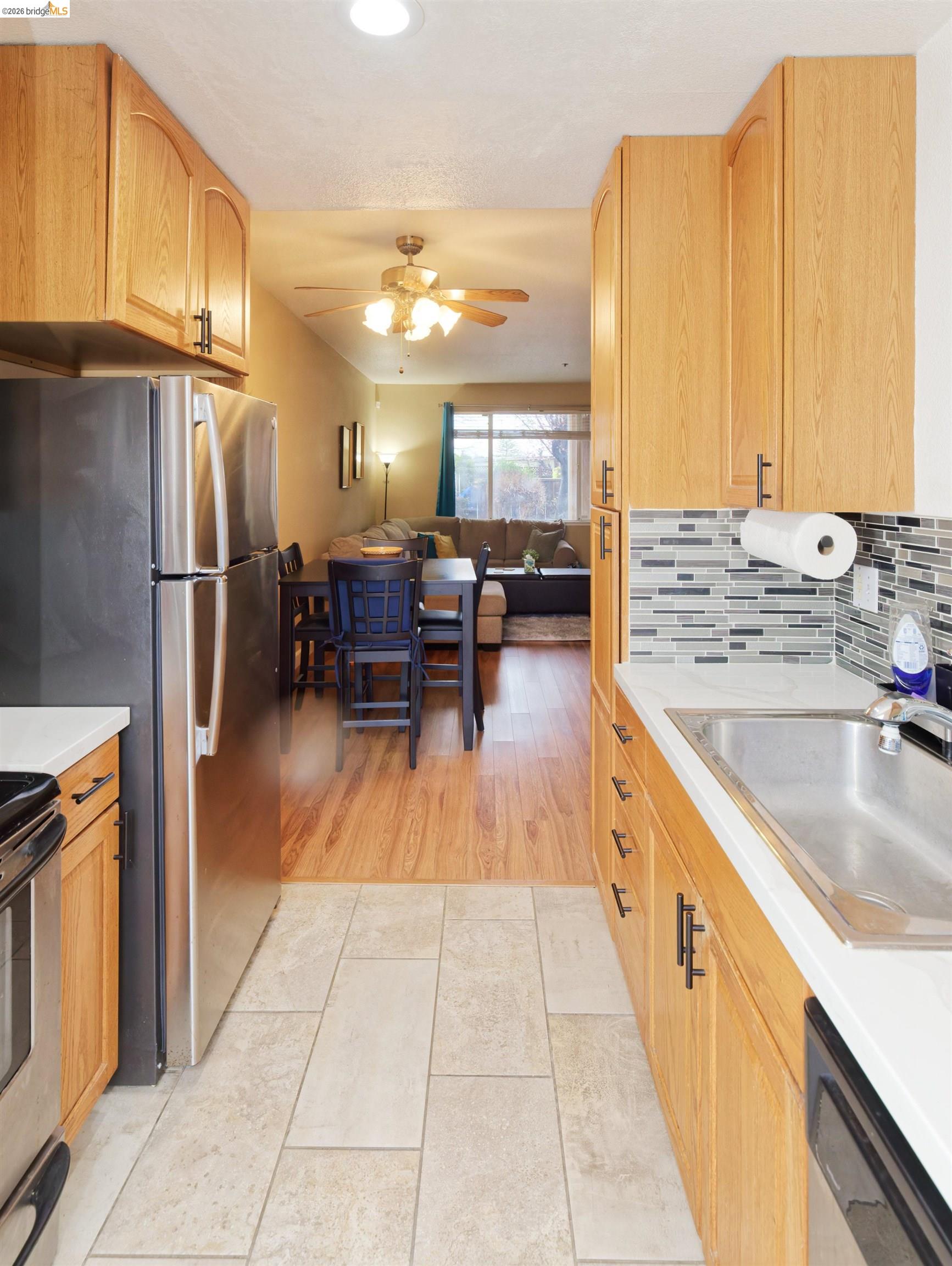 10 Leighty Court, Unit 5 Hayward, CA 94541 - Photo 22 of 22 Kitchen featuring open floor plan, light countertops, stainless steel appliances, light tile patterned flooring, and light wood finish cabinetry