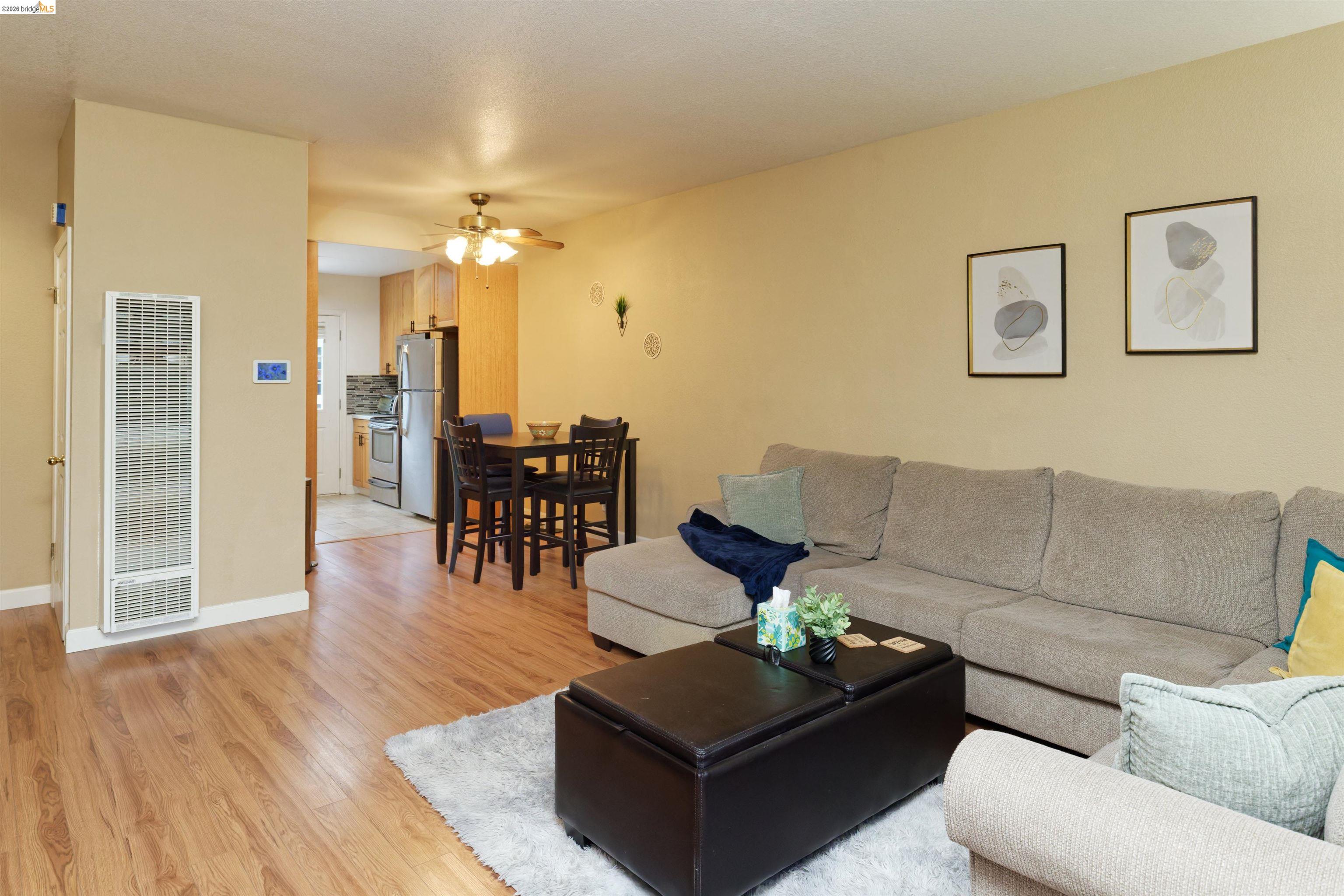 10 Leighty Court, Unit 5 Hayward, CA 94541 - Photo 10 of 22 Living area featuring a heating unit, light wood finished floors, and a ceiling fan