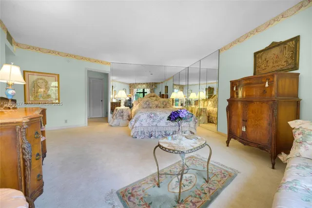 a large bedroom with a large bed and chandelier
