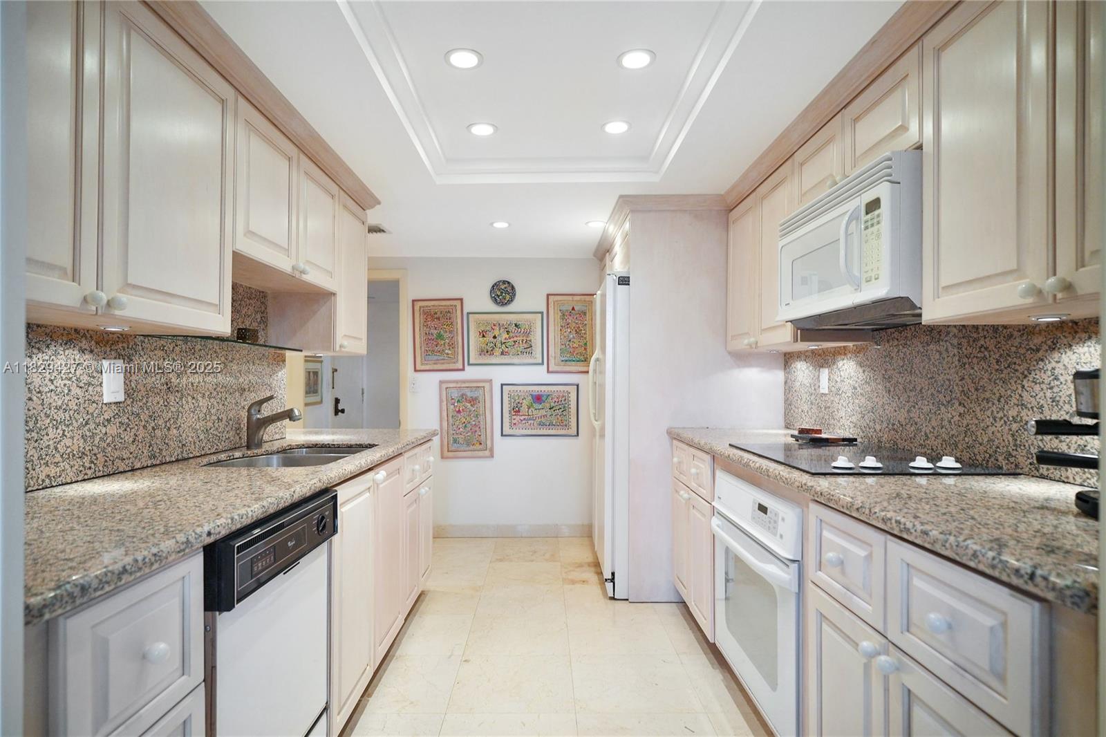 1121 Crandon Boulevard, Unit F201 Key Biscayne, FL 33149 - Photo 39 of 56 a kitchen with stainless steel appliances granite countertop a sink stove and cabinets