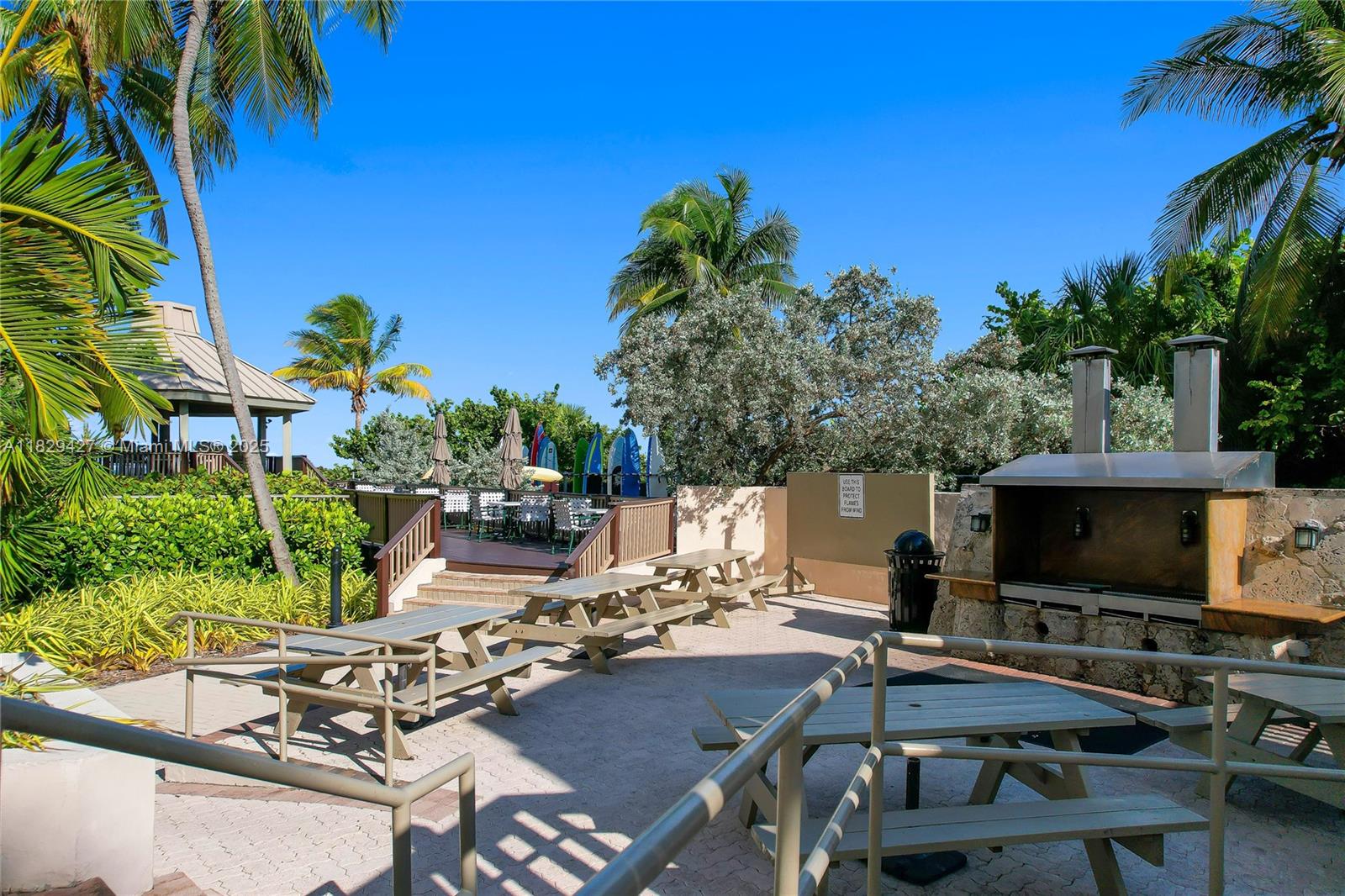 1121 Crandon Boulevard, Unit F201 Key Biscayne, FL 33149 - Photo 9 of 56 a view of a chairs and table in a backyard