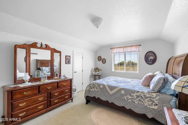 a bedroom with a bed and a large mirror on the dresser