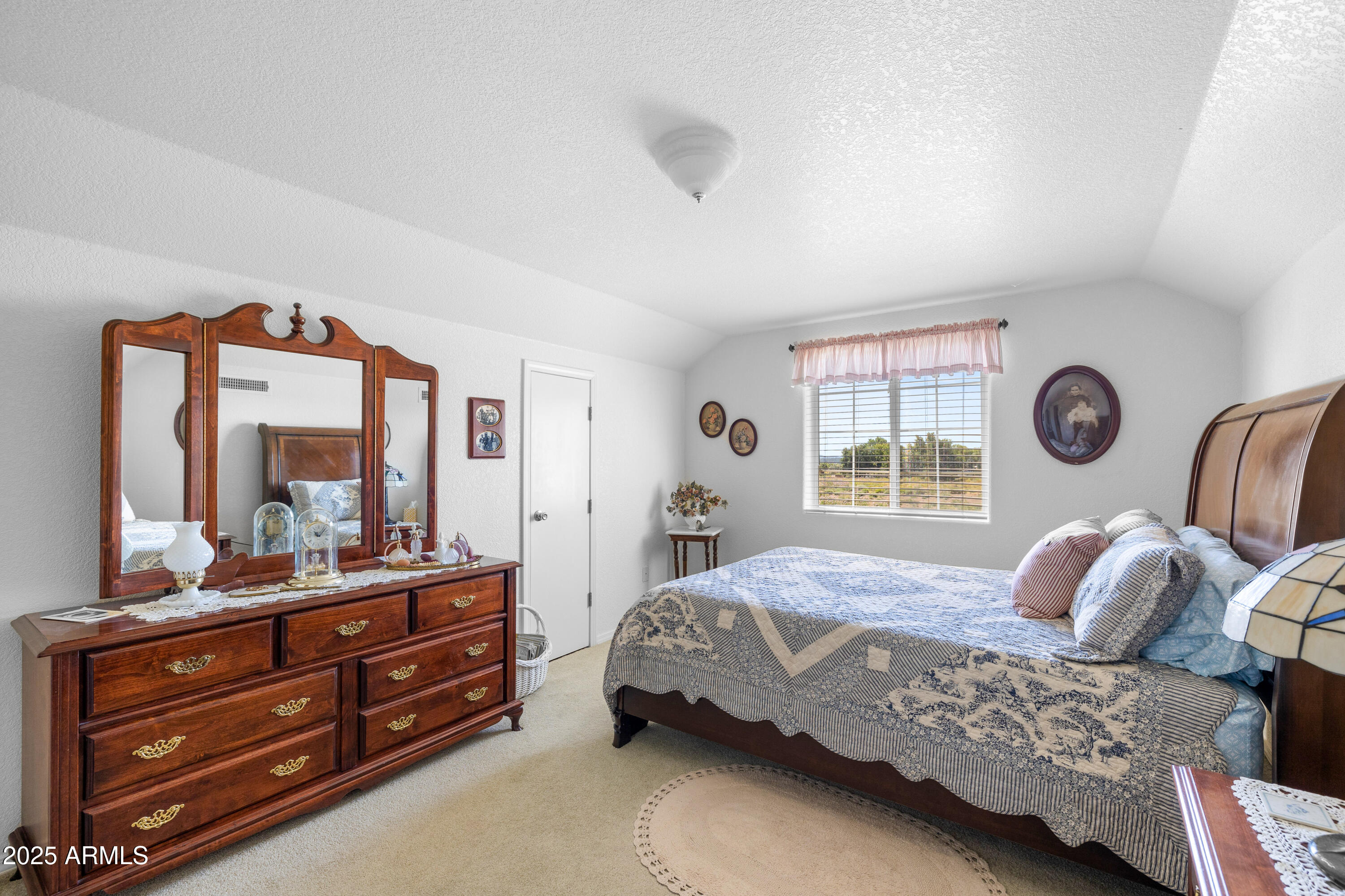 12870 Doyle Road Flagstaff, AZ 86004 - Photo 28 of 49 a bedroom with a bed and a large mirror on the dresser