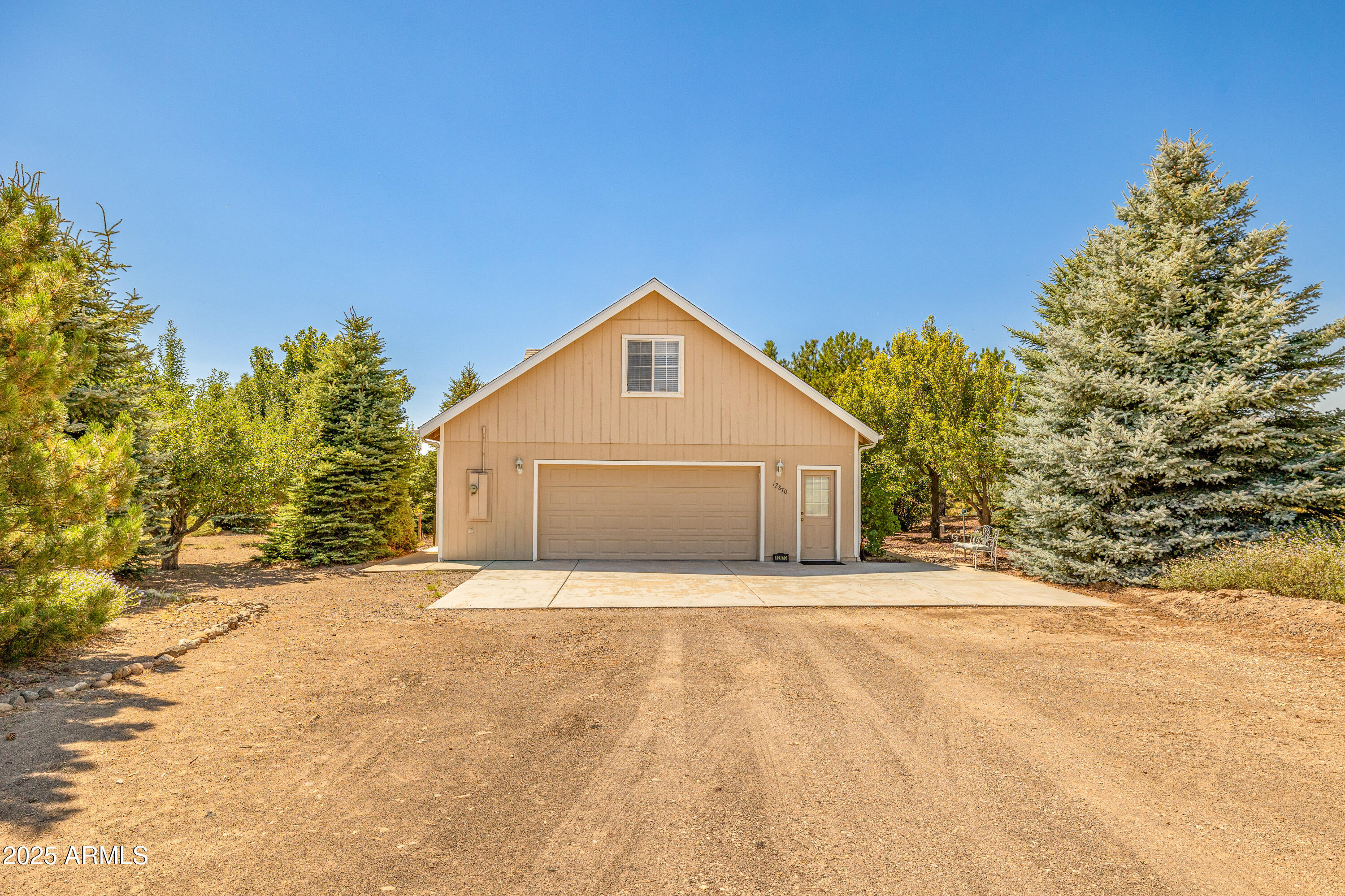 12870 Doyle Road Flagstaff, AZ 86004 - Photo 30 of 49 a front view of a house with a yard and garage