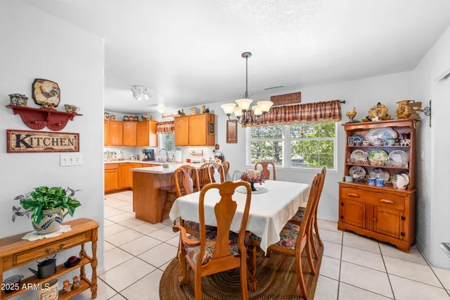 a view of a dining room and livingroom with furniture wooden floor a chandelier