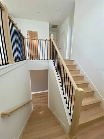 a view of hallway with window and wooden floor