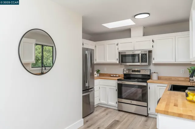 a kitchen with stainless steel appliances a white stove top oven and sink