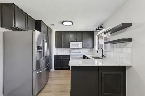 a kitchen with stainless steel appliances granite countertop a refrigerator and a sink