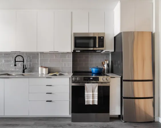 a kitchen with stainless steel appliances granite countertop a refrigerator stove a sink and a microwave