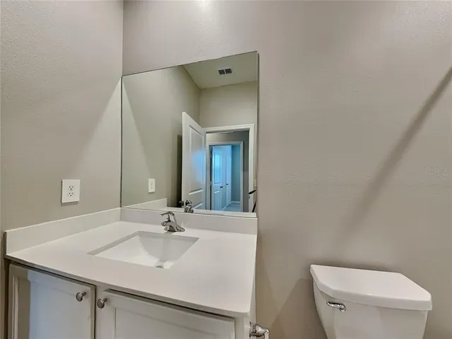 a bathroom with a sink toilet and mirror