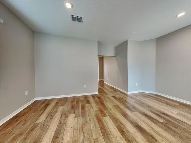 a view of empty room with wooden floor