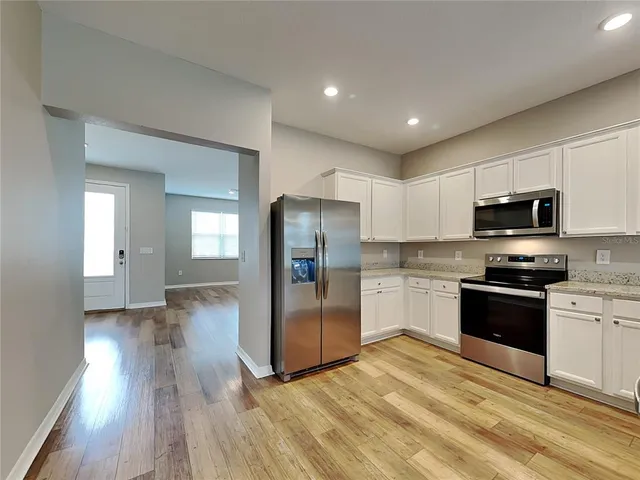 a kitchen with stainless steel appliances granite countertop a refrigerator and a stove top oven