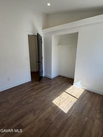 an empty room with wooden floor and closet