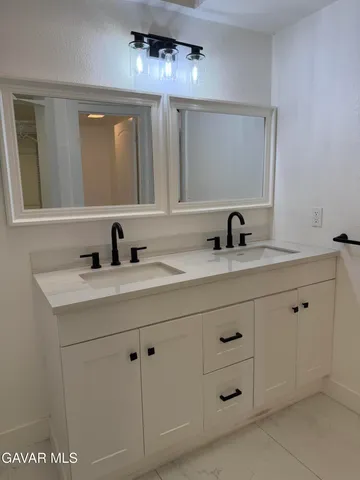 a bathroom with a double vanity sink and mirror