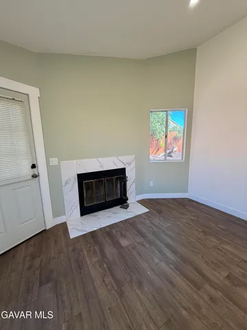 an empty room with wooden floor and fireplace