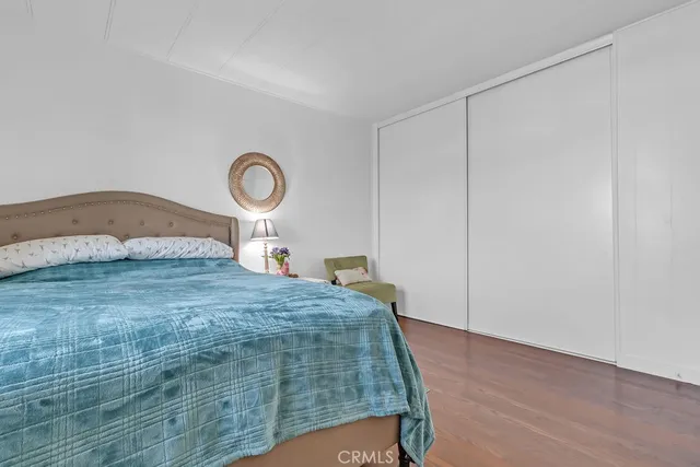 a bedroom with a bed and a lamp on the dresser