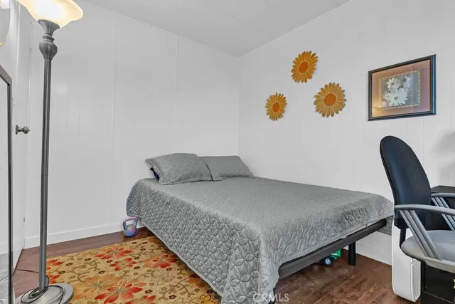 a bedroom with a bed and painting on the wall