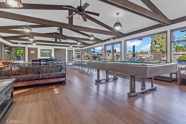 a living room with furniture a flat screen tv and floor to ceiling window