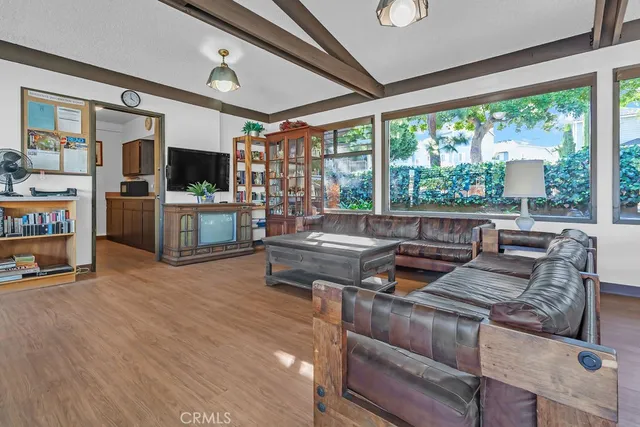 a dining room with wooden floor a chandelier a glass table and windows