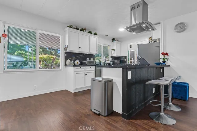 a kitchen with granite countertop a table chairs a stove a sink and a window