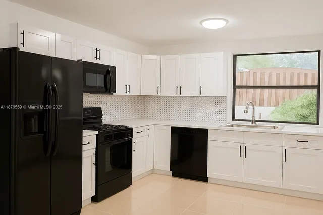 a kitchen with a refrigerator and white cabinets