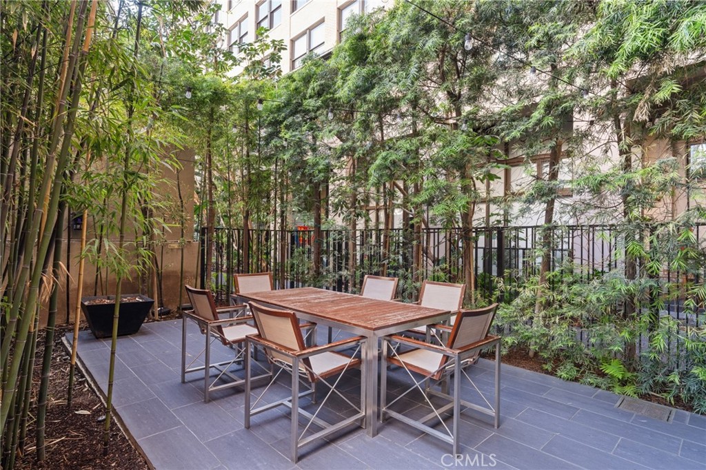 460 South Spring Street, Unit 302 Los Angeles, CA 90013 - Photo 16 of 24 a view of a patio with a table and chairs next to a yard