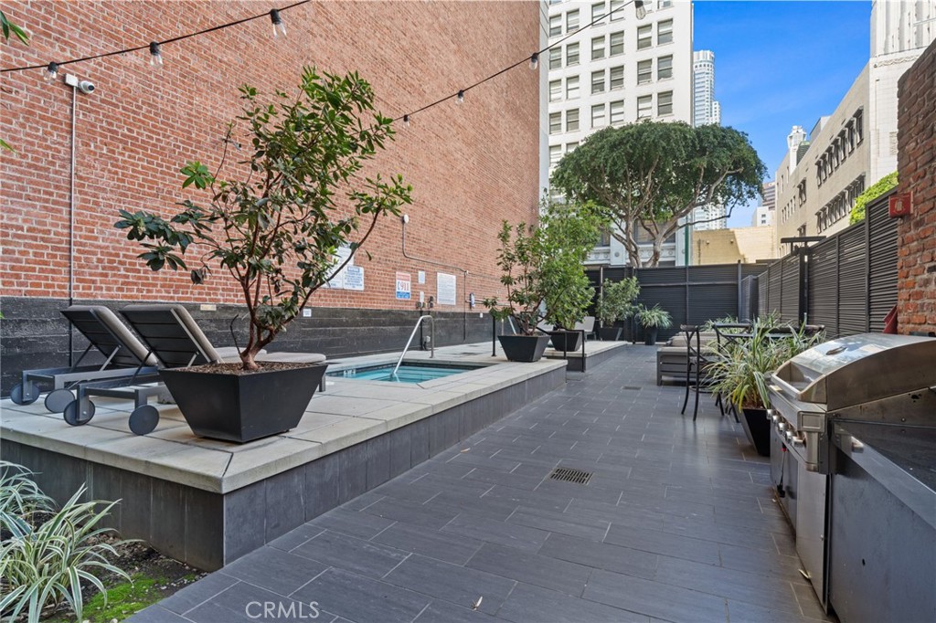 460 South Spring Street, Unit 302 Los Angeles, CA 90013 - Photo 18 of 24 a view of a patio with table and chairs and potted plants