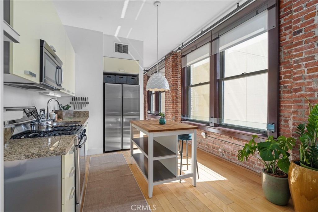 460 South Spring Street, Unit 302 Los Angeles, CA 90013 - Photo 10 of 24 a kitchen with stainless steel appliances granite countertop a stove a sink and a refrigerator