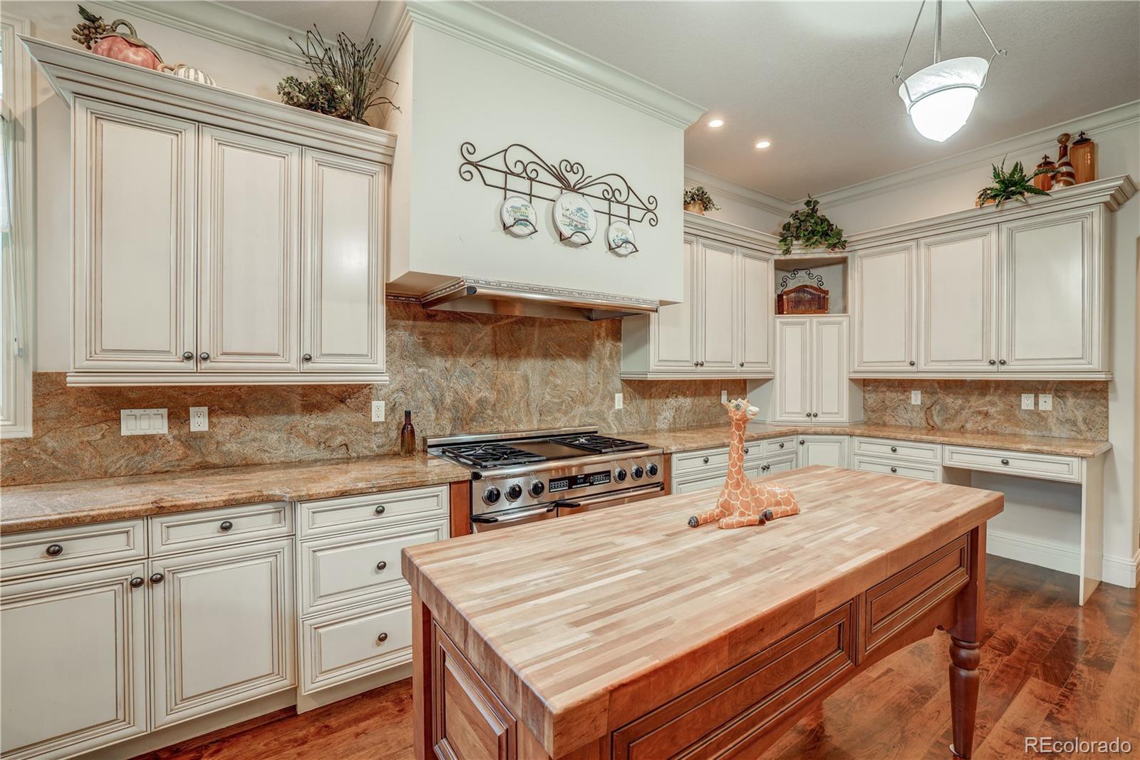 23 Foxtail Circle Cherry Hills Village, CO 80113 - Photo 17 of 40 a kitchen with kitchen island granite countertop a sink cabinets and wooden floor