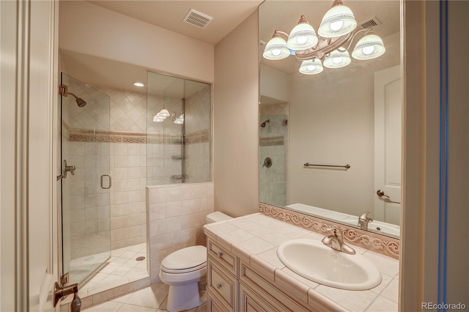 23 Foxtail Circle Cherry Hills Village, CO 80113 - Photo 35 of 40 a bathroom with a sink a toilet a mirror and shower