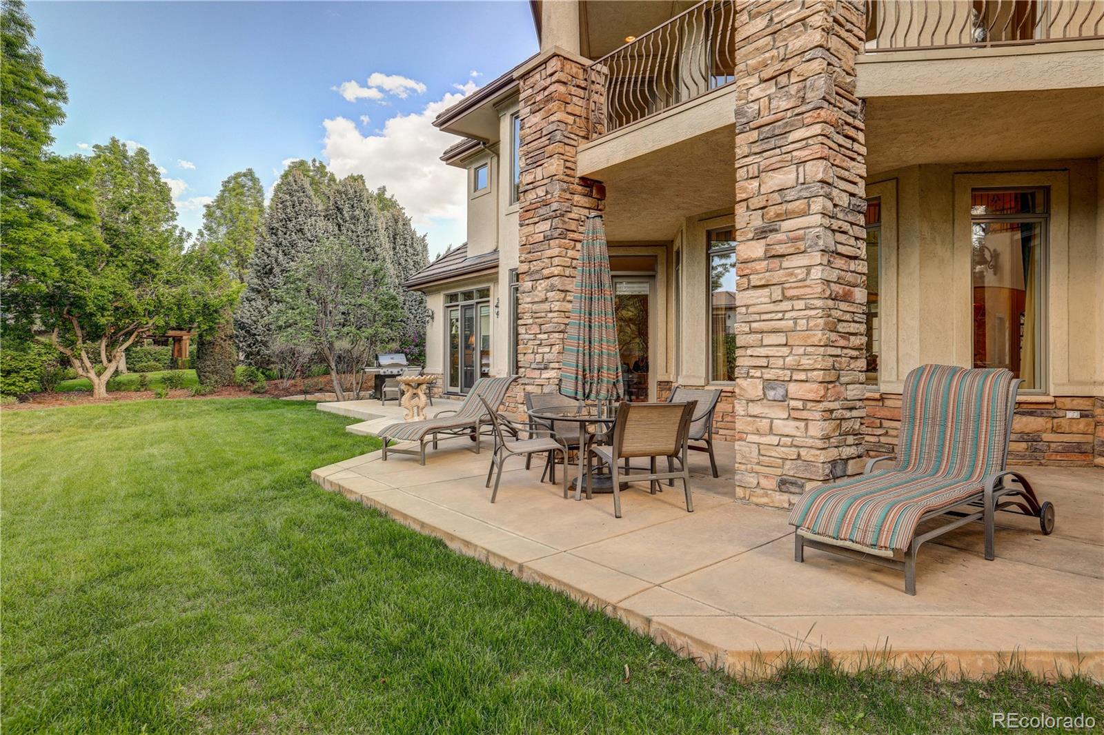 23 Foxtail Circle Cherry Hills Village, CO 80113 - Photo 6 of 40 a view of a patio with table and chairs with a yard and plants