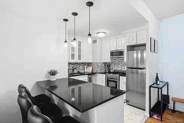 a kitchen with stainless steel appliances granite countertop a sink refrigerator and microwave