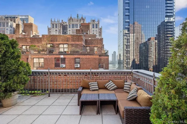 a view of roof deck with couch and chairs