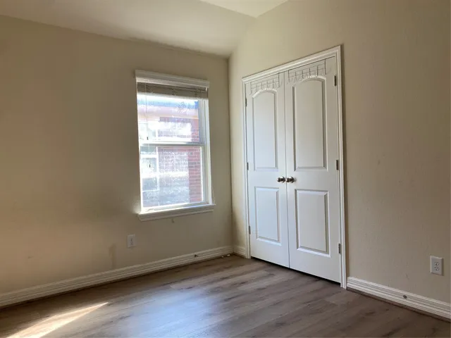 an empty room with wooden floor and a window