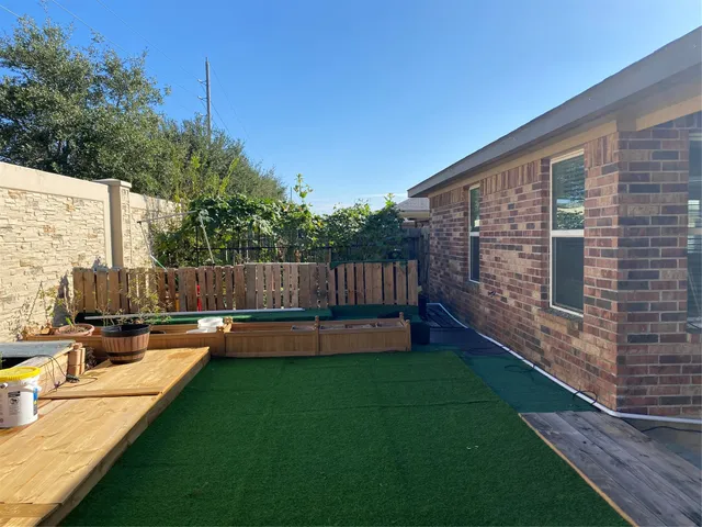 a view of a backyard with sitting area and wooden fence